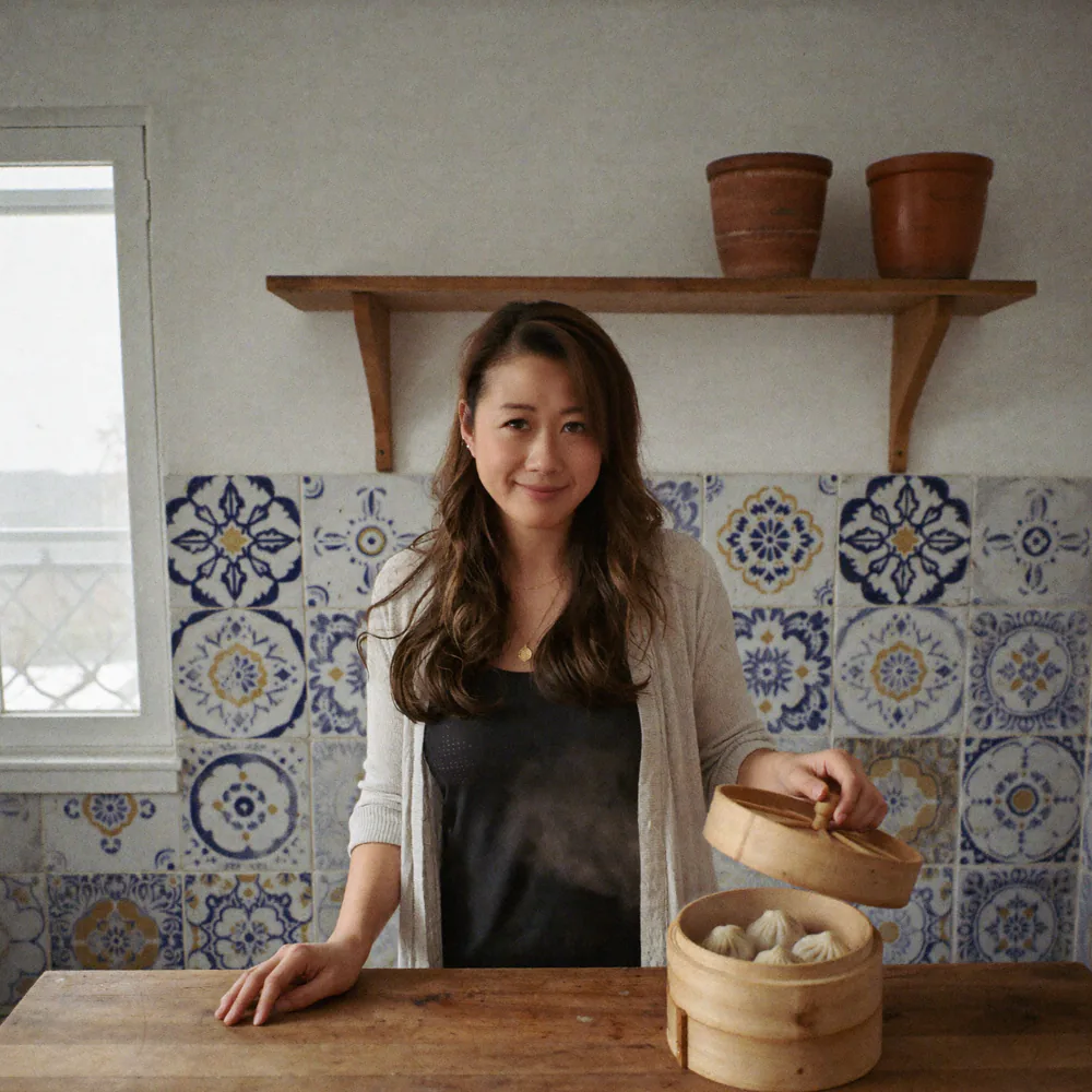 Sam at her kitchen island with a bamboo steamer of dumplings